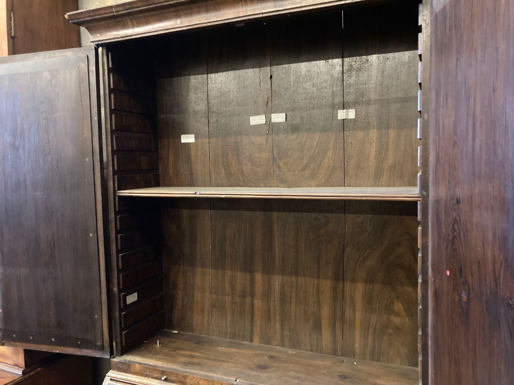 A mid 18th century style walnut bureau bookcase, with two mirrored doors enclosing a single adjustable shelf over candle slides and fal